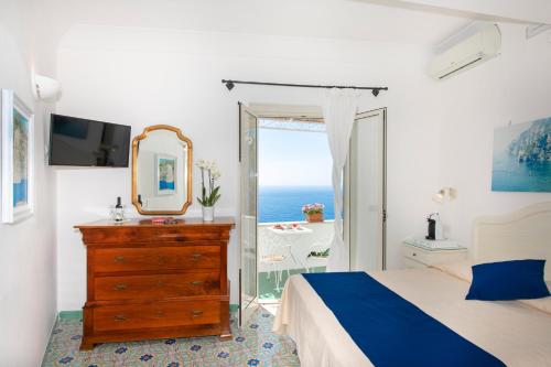 a bedroom with a bed and a mirror and a dresser at Casa Guadagno in Positano