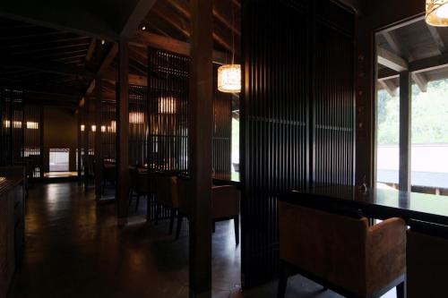 a dining room with tables and chairs and windows at Yamado in Nishiwaga