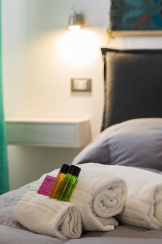 a pile of towels on a bed with a lamp at My Way - Suite - Rooms - Palazzo San Matteo in Palermo