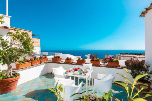a balcony with a table and chairs and the ocean at Casa Guadagno in Positano