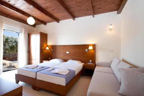 Habitación de hotel con cama y sofá en Giorgi's Blue Apartments, en Kalathas