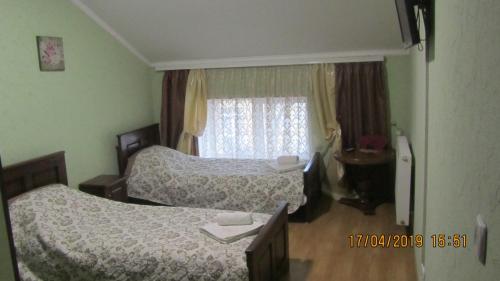 a bedroom with two beds and a window at Diamond De Luxe in Kolomyya