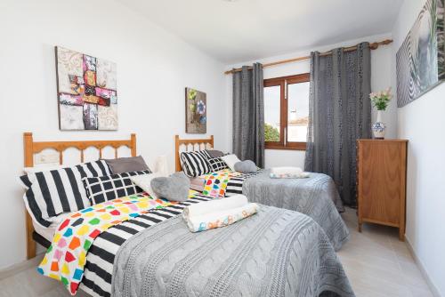 a bedroom with two beds and a window at Ropit in Port d'Alcudia