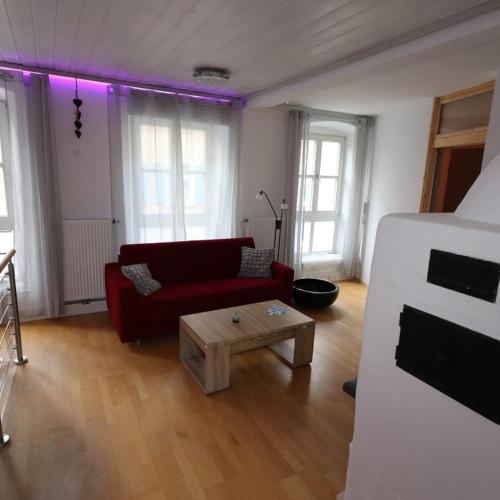 ein Wohnzimmer mit einer roten Couch und lila Beleuchtung in der Unterkunft Ferienwohnung Stiftstadt Kempten in Kempten