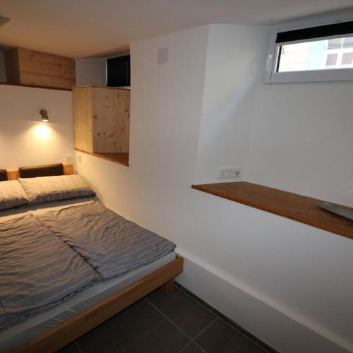 ein kleines Schlafzimmer mit einem Bett und einem Fenster in der Unterkunft Ferienwohnung Stiftstadt Kempten in Kempten