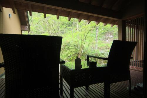 a porch with two chairs and a table and a window at Yamado in Nishiwaga