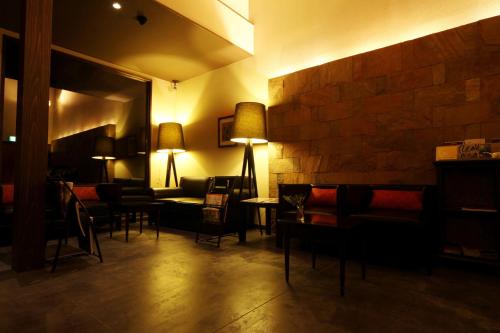 a lobby with couches and chairs and a brick wall at Yamado in Nishiwaga