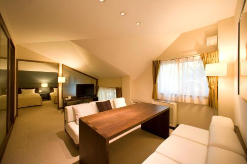 a hotel room with a desk and a bedroom at Sundance Resort Karuizawa in Karuizawa