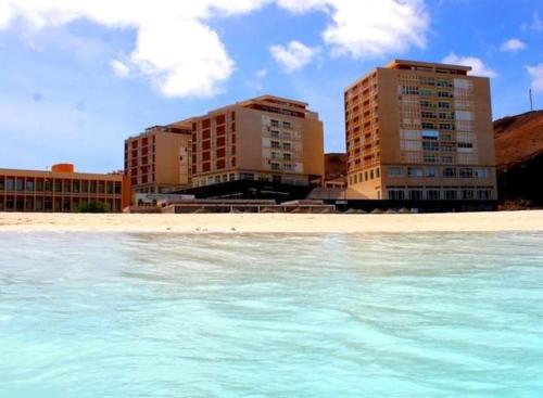 a view of a beach with two tall buildings at @Georgette in Mindelo
