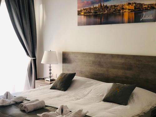 1 dormitorio con 1 cama con toallas en Napoli Suites, en San Julián
