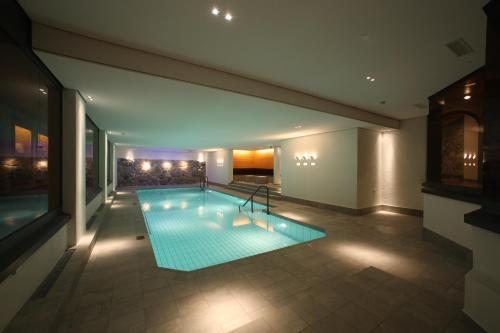 - une piscine au milieu d'un bâtiment dans l'établissement Bernerhof Swiss Quality Hotel Gstaad, à Gstaad