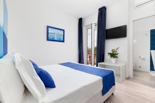 a bedroom with a white bed with blue accents at Eden Bleu in Vico Equense