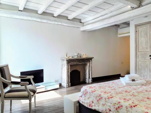 a bedroom with a bed and a chair and a fireplace at Incredible Views in Campo de Fiori in Rome