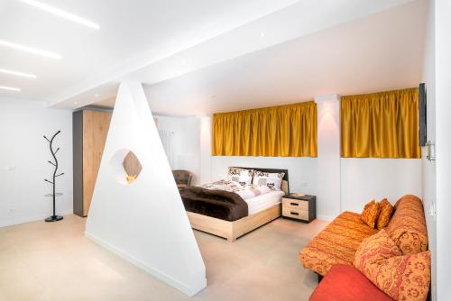 - un salon avec un lit et un canapé dans l'établissement Fior Apartments Lofts, à Merano