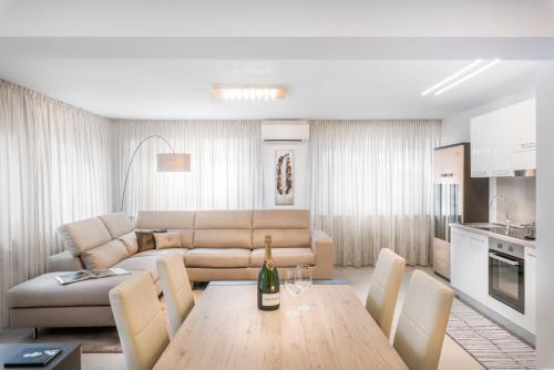 - un salon avec un canapé et une table avec une bouteille de vin dans l'établissement Fior Apartments Lofts, à Merano