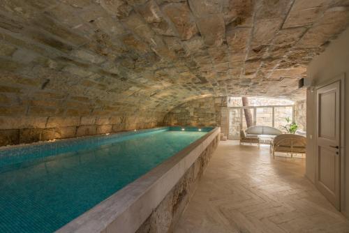 a swimming pool in a cave with a stone wall at Villa Galatea in San Vincenzo