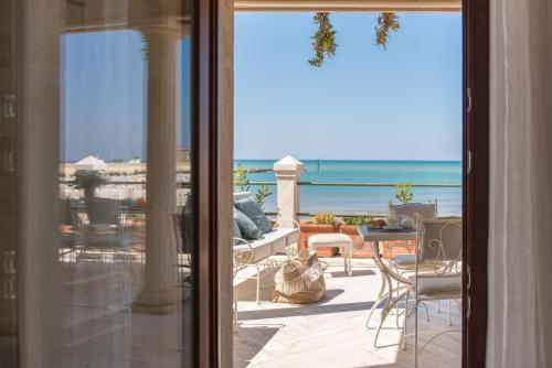 a room with a view of the ocean from a balcony at Villa Galatea in San Vincenzo