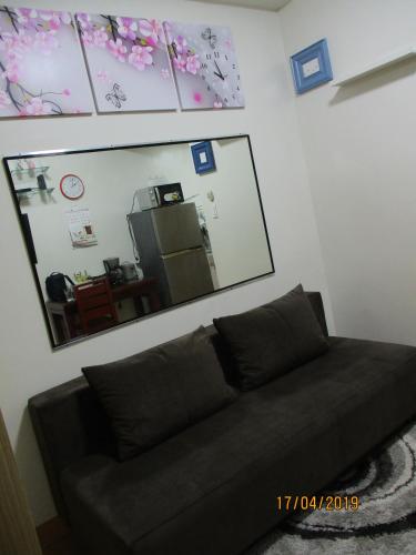 a black couch in a living room with a mirror at XNY at SMDC Trees Residences Quezon City-1 Bed RoomT2 in Manila