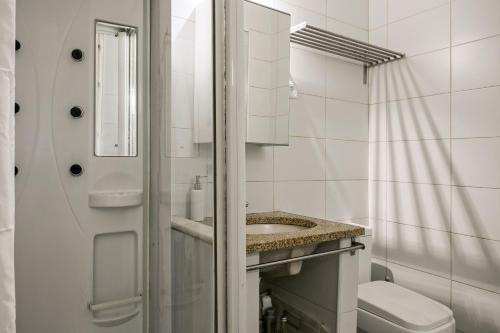 a white bathroom with a sink and a toilet at Cozy Studio in Central Bairro Alto in Lisbon