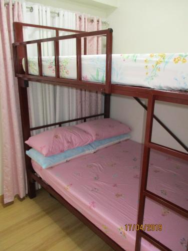 two bunk beds in a room with pink sheets at XNY at SMDC Trees Residences Quezon City-1 Bed RoomT2 in Manila
