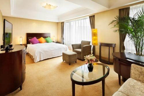 a hotel room with a bed and a table at Furama Hotel Dalian in Dalian