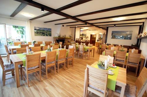 comedor con mesas y sillas de madera en Pension Bergterrasse, en Annweiler am Trifels