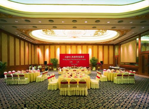 a banquet hall with tables and chairs in a building at Furama Hotel Dalian in Dalian