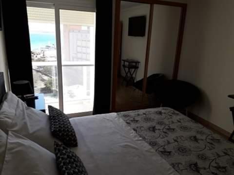 a bedroom with a bed and a large window at @Georgette in Mindelo