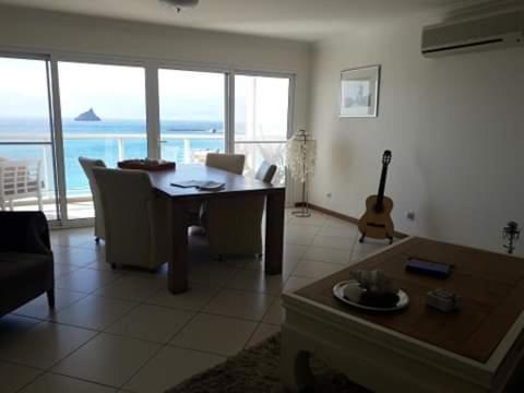 a living room with a table and a guitar at @Georgette in Mindelo
