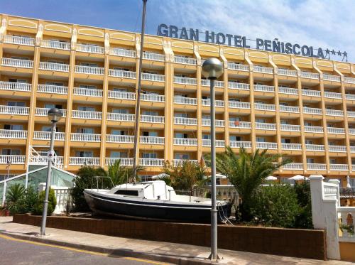 a boat in front of a large building at Gran Hotel Peñiscola in Peñíscola
