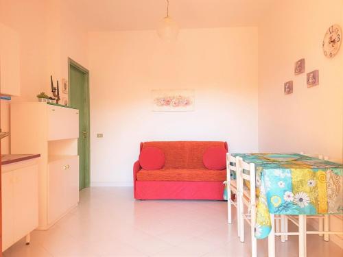a room with a table and a couch and a table at Sunny garden house in Villasimius