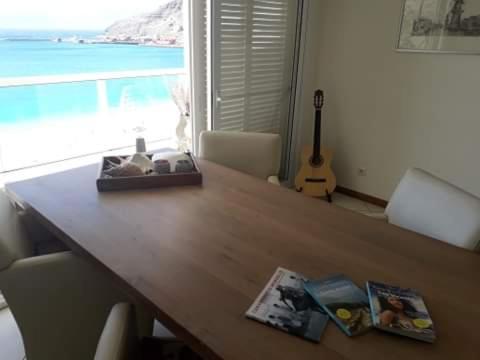 a wooden table with a view of the ocean and a guitar at @Georgette in Mindelo