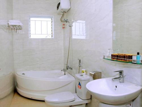 a bathroom with a tub and a sink and a toilet at My Vy Khanh Hotel in Da Nang