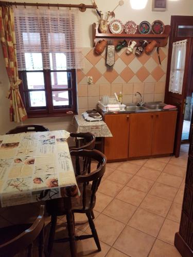 a kitchen with a table and chairs and a sink at Folyóka Vendégház in Egyházasgerge