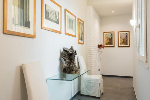 a room with a glass table and some pictures on the wall at My Way - Suite - Rooms - Palazzo San Matteo in Palermo
