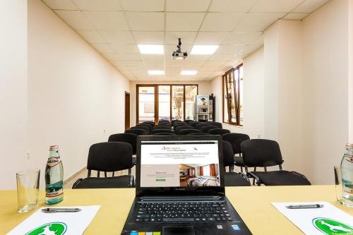 a conference room with a laptop on a table with chairs at Family Hotel Romantika in Velingrad