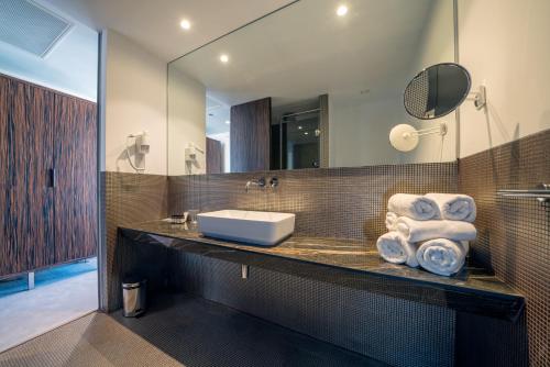 a bathroom with a sink and a mirror at Bellevue Superior City Hotel in Šibenik