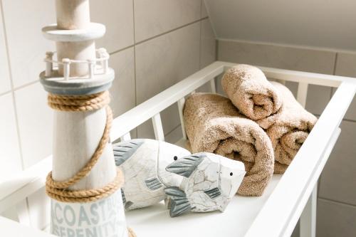 a white shelf with towels and towels on it at Apartment in der Alexandrinenstrasse in Warnemünde