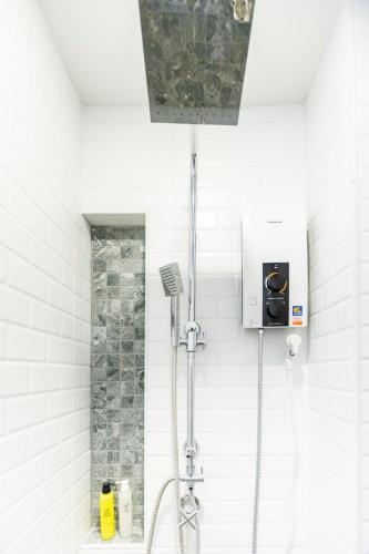 a shower in a white bathroom with a sink at พรนับพันเพลส in Chiang Mai