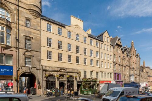 Destiny Scotland - Royal Mile Residence في إدنبرة: مبنى كبير على شارع المدينة وبه سيارات