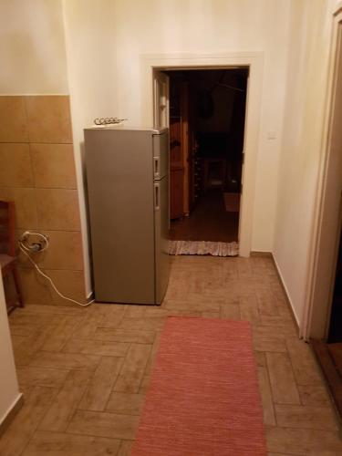 a kitchen with a refrigerator in a hallway at Folyóka Vendégház in Egyházasgerge