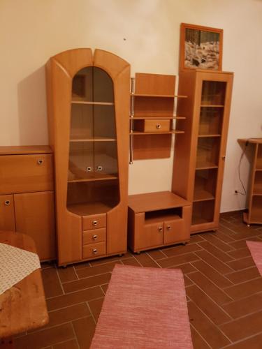a room with a wooden cabinet and a mirror at Folyóka Vendégház in Egyházasgerge