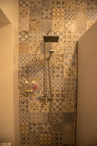 a bathroom with a shower with a tile wall at Cantagua Hostel in Valencia