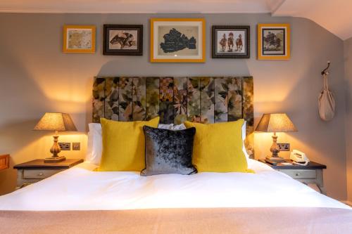 a bedroom with a large white bed with yellow pillows at The Foley in Claygate