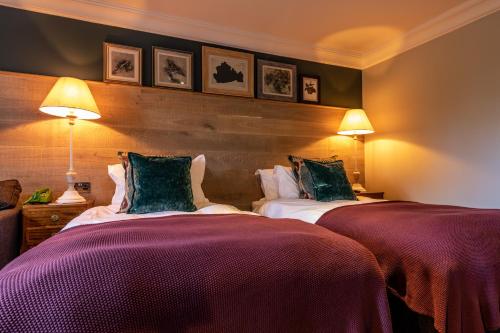 a hotel room with two beds and two lamps at The Foley in Claygate