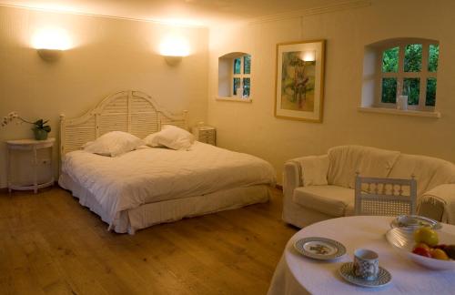 ein Schlafzimmer mit einem Bett, einem Sofa und einem Tisch in der Unterkunft Veerhoeve in Sluis