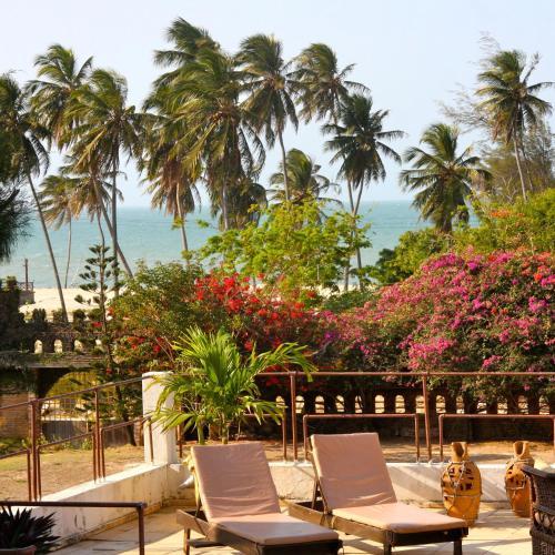 a view of the beach and palm trees and chairs at Casa Cohiba in Cumbuco