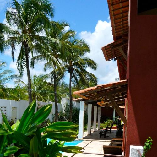 a resort with palm trees and a building with a patio at Casa Cohiba in Cumbuco