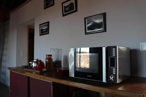 a microwave sitting on top of a wooden counter at Adega Fraga in Santa Luzia