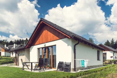 a small white house with a wooden roof at Residence Lipno in Lipno nad Vltavou
